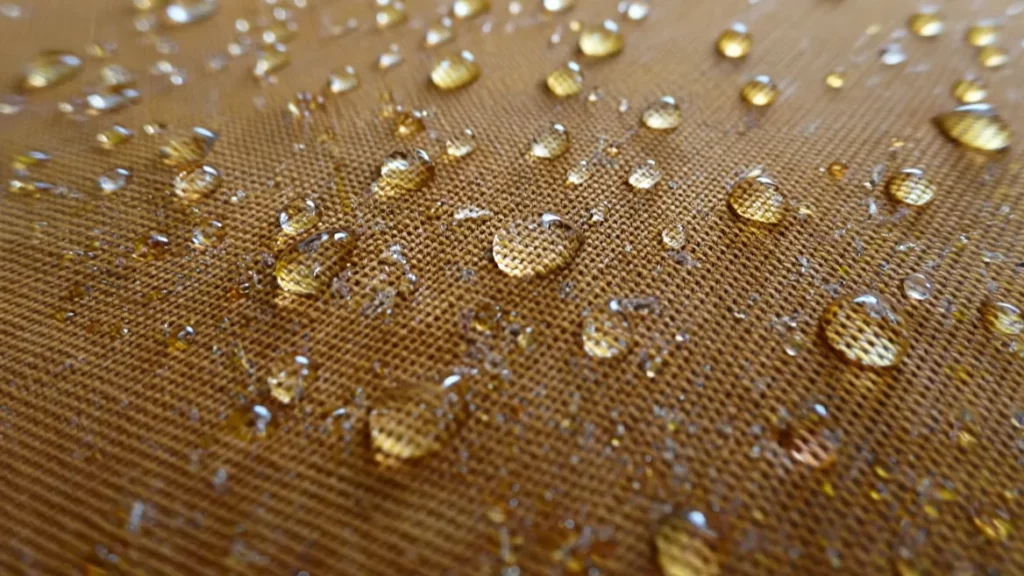 Gouttes d'eau perlant sur un tissu imperméabilisé